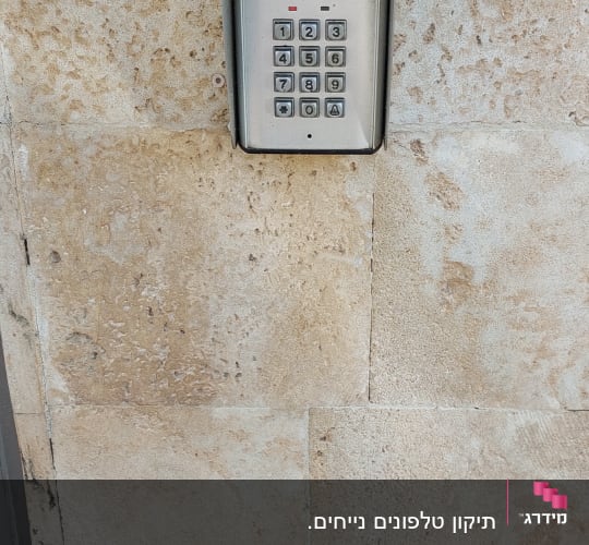 אינטרקום עם לוח מקשים על קיר אבן